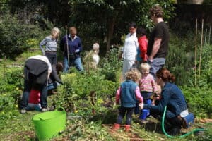 kids and adults working in a garden