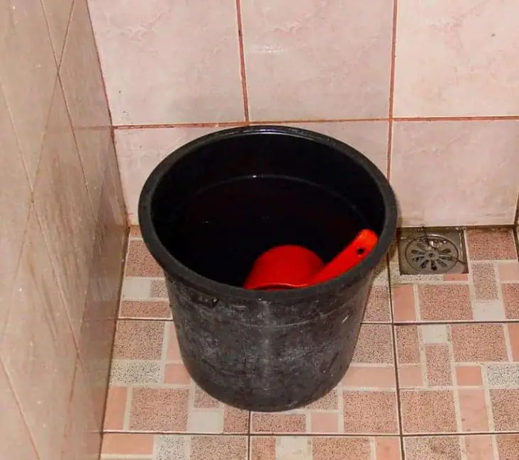 The Philippines Tabo. A black bucket on the floor with a red pail