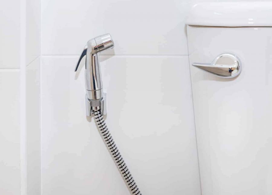 Stainless steel handheld bidet sprayer in toilet bathroom