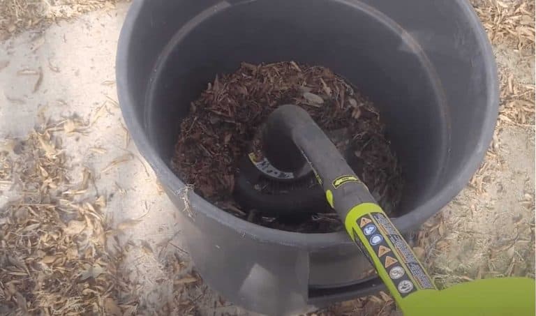 Leaves in a bin being shredded by a weed wacker