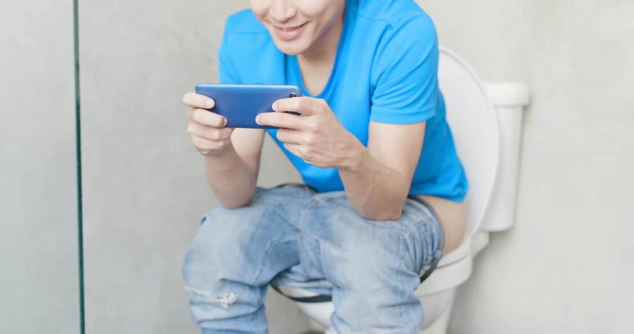 man use phone on toilet