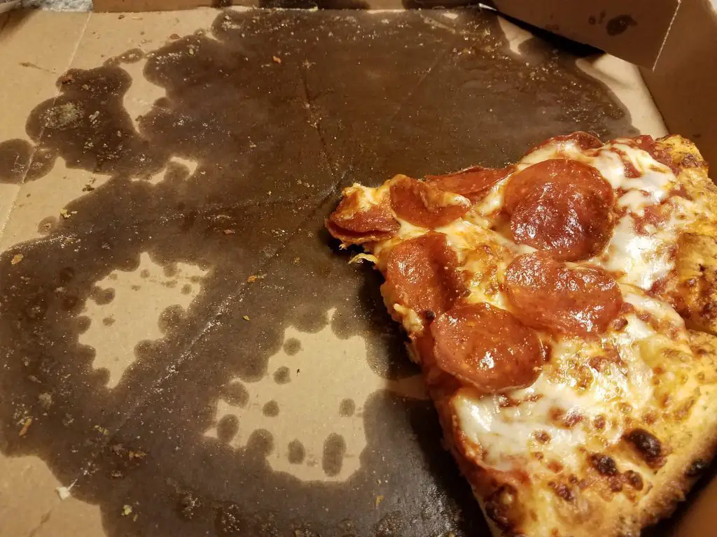 greasy slices of pepperoni pizza in a pizza box